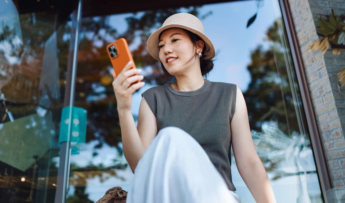 A smiling woman looking at her phone