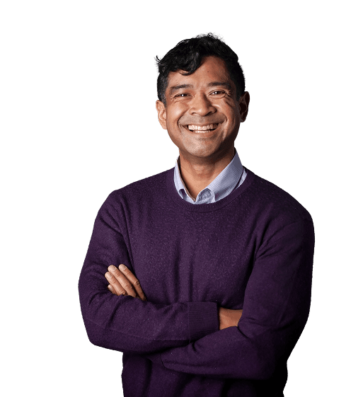 Man in purple jumper with arms folded smiling at the camera
