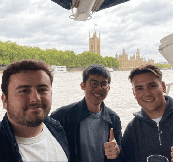 Three men smiling in front of Big Ben