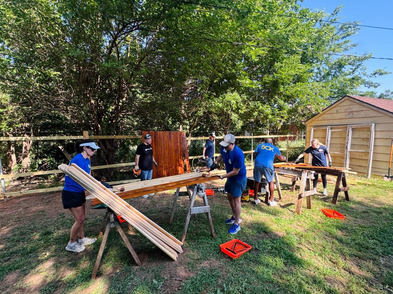 Colleagues volunteering in their community, outside with building materials